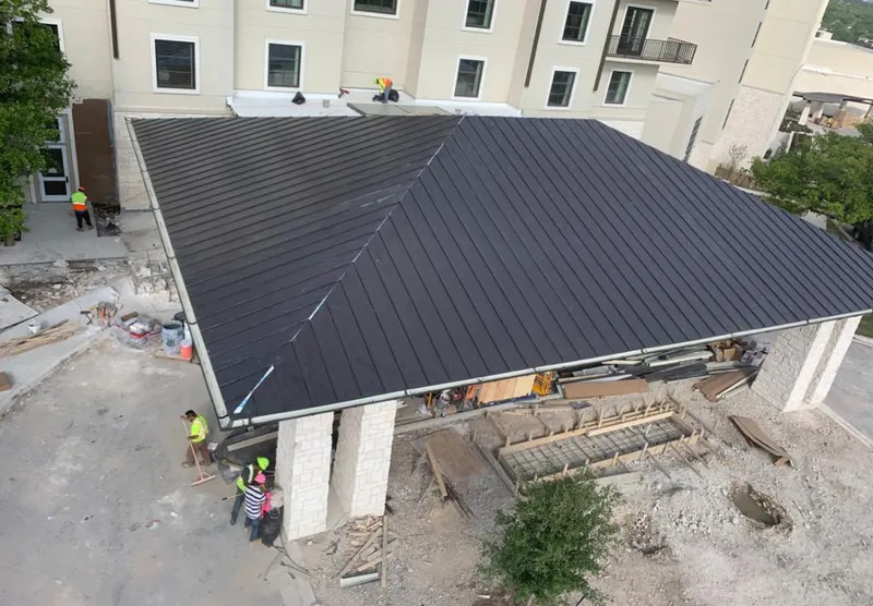 Metal roofing installation team working on a commercial building in Sussex